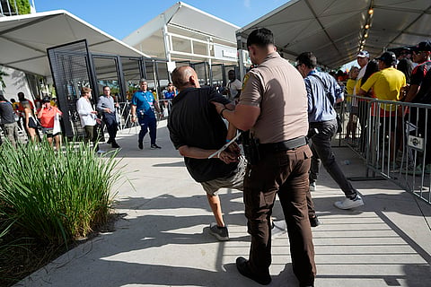 A man is detained by police outside the stadium